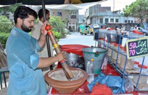 A vendor busy in preparing traditional summer drink (Sardai) for customers at his roadside setup.