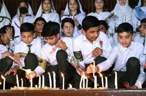 Students of APS observing candle vigil in memory of the victims of May 9 at Radio Pakistan.