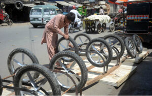 Worker installing new tyres on hand cart at his roadside setup in the city