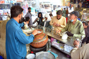 People drinking traditional summer drink (Lassi) from vendor to get relief from hot weather in the city.