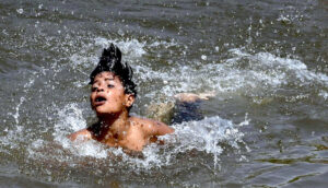 A youngster enjoy swimming in canal to get some relief from hot weather in Federal Capital.