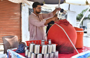 A vendor preparing traditional drink (Lassi) to attract customers during hot weather in the city