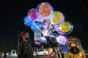 A vendor displaying colorful balloons to attract the customers at College Road.