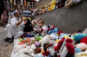 An old man is selling and displaying second hand imported toys to attract the customers at Kohati area.