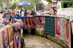 Vendor selling and displaying traditional carpets to attract the customers at Shahi Katha.