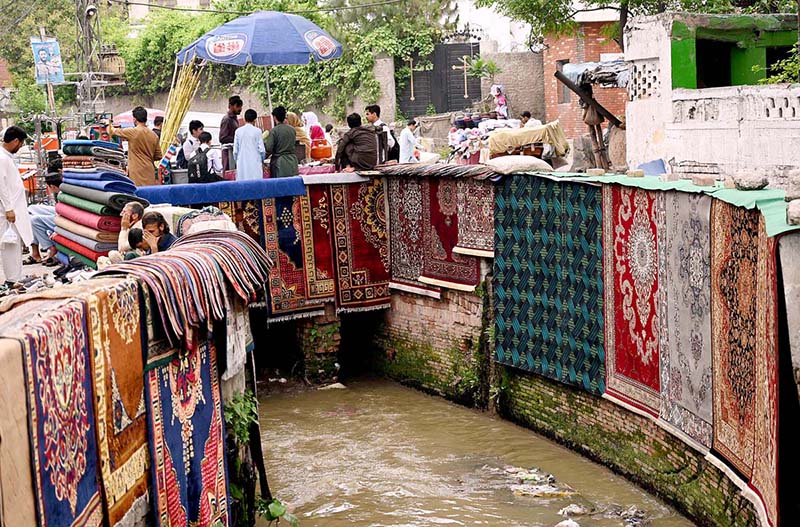 Vendor selling and displaying traditional carpets to attract the customers at Shahi Katha.