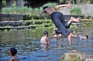 Youngsters jumping and bathing in Korang Nullah to get relief from hot weather in Federal Capital.