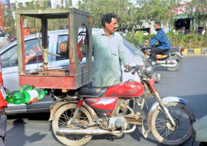 A motorcyclist on the way loaded with room cooler in Provincial Capital.