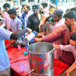 Volunteers offering summer drink to people at heat stroke camp organized by Pukar welfare organization due to scorching hot weather at Qasimabad