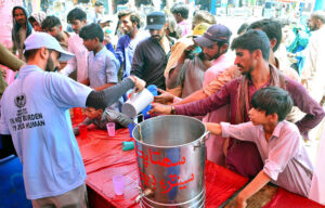 Volunteers offering summer drink to people at heat stroke camp organized by Pukar welfare organization due to scorching hot weather at Qasimabad
