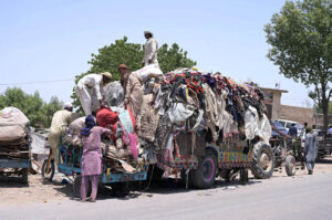 Labourers busy in loading old clothes on tractor trolley for delivery to garbage factory at Tando Yosuf Road.