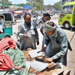 People purchasing the ice from roadside vendor during hot day in the city at Hali Road