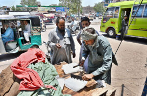 People purchasing the ice from roadside vendor during hot day in the city at Hali Road