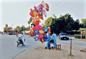 A vendor displaying gas filled balloons to attract the customers.