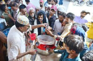 Volunteers offering summer drink to people at heat stroke camp established in Latifabad due to scorching hot weather in the city.