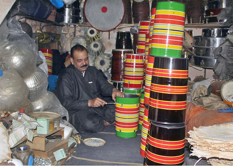 Shopkeeper displaying and preparing traditional musical instruments to attract the customers.