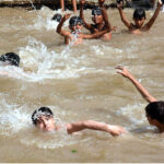 Youngsters enjoy bathing in pond to get some relief from hot weather in the Provincial Capital