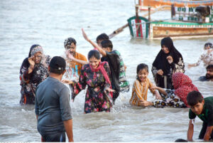 People enjoy bathing in the Indus River to get relief from hot weather in the city.