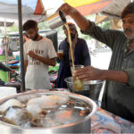 A vendor selling traditional summer drink (Shakar Cola) at his roadside setup.
