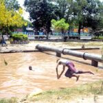 Youngsters jumping and bathing in to the canal to get relief from hot weather in the city