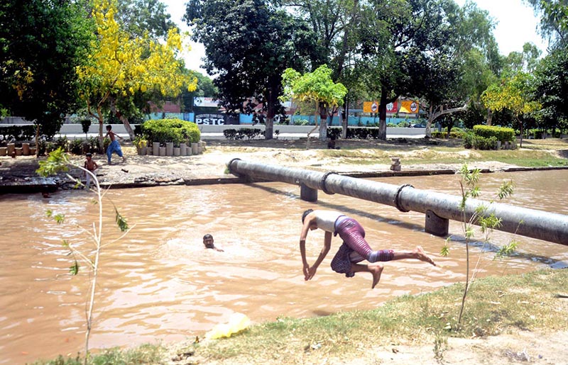 Youngsters jumping and bathing in to the canal to get relief from hot weather in the city