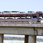 A trawler on the way loaded with vehicles crossing Indus River Bridge at Bypass.