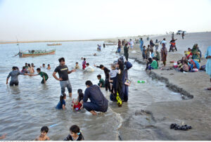 People enjoy bathing in the Indus River to get relief from hot weather in the city.