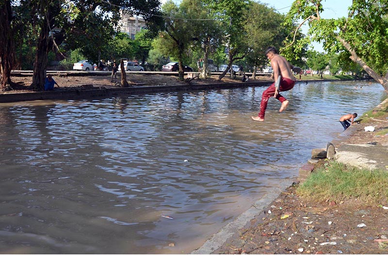Youngster jumping into the canal to get relief from hot and humid weather in the Provincial Capital.