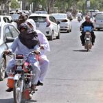A motorcyclist covered his head and face to protect himself from scorching heat at Club Road.