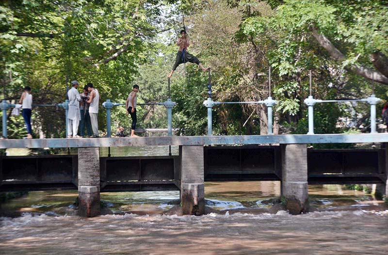 Youngsters jumping for bathing in water canal to get relief from hot weather in the city.