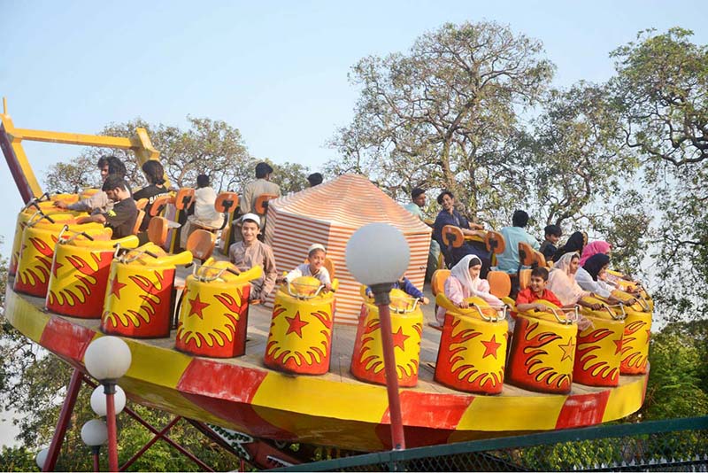 People enjoying mechanized swing at Gulshan-e-Iqbal Park