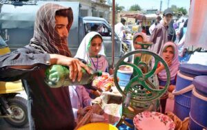 A vendor selling ice-lolly to customers at during scorching hot weather in the city.