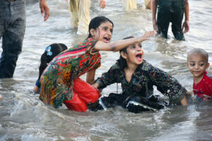 People enjoy bathing in the Indus River to get relief from hot weather in the city.
