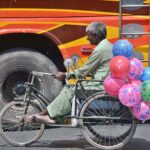 A disable vendor on the way on tricycle wheelchair selling balls to earn livelihood.