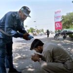 A traffic warden helping a citizen suffered from hot weather at Club Chowk during scorching hot weather in the city.
