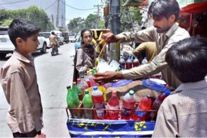 A vendor preparing ice balls for children at his roadside setup