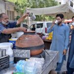 A vendor selling traditional drink (lassi) on his cart at Shaheen Chowk