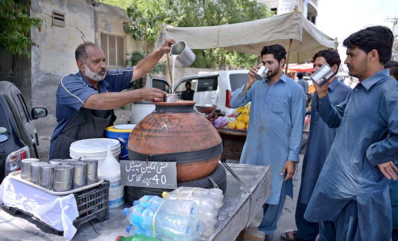 A vendor selling traditional drink (lassi) on his cart at Shaheen Chowk