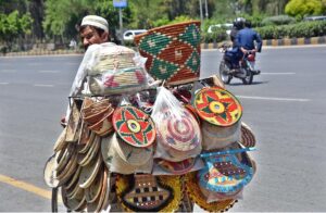 A vendor on the way on bicycle loaded with handmade items in Federal Capital.