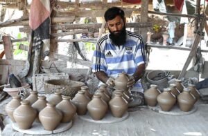 A craftsman busy in preparing the clay-made stuff at his workplace in Kumharpara area.