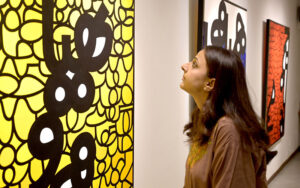 Visitor viewing painting during exhibition “Archipelago of the Self” at Tanzara Gallery.