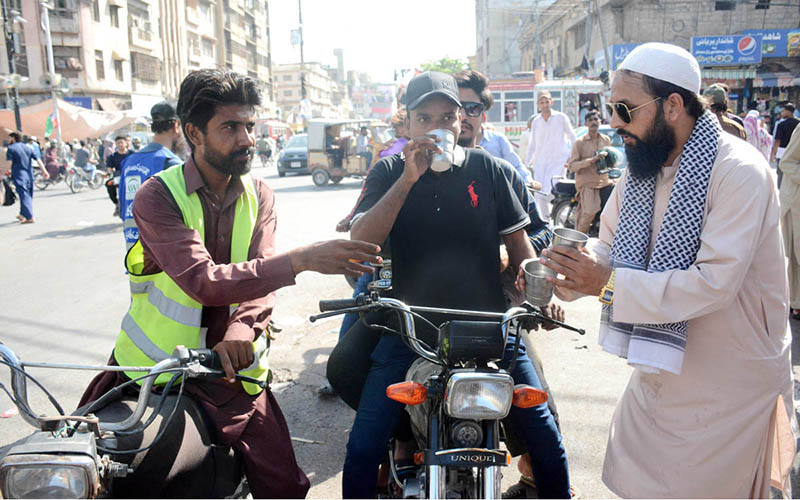Volunteers offer water to bikers, providing much-needed relief as temperatures soar in the city