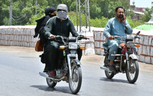 Motorcyclist covers his face with a handkerchief to protect from scorching heat at Hilltop Road during scorching hot weather in the city.