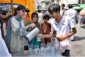 Members are giving cold water to people during "Heat Wave Mitigation Campaign" organized by Civil Services Academy, Community Development and Environment Society at Hall Road.