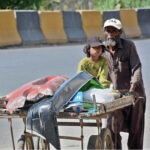 A street vendor pushes a hand cart loaded with scraps, carrying a child along the way, showcasing resilience and dedication to earn livelihood for family