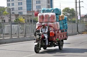 A loader rickshaw driver on his way loaded with water cooler at Ferozepur Road to deliver in a local market.
