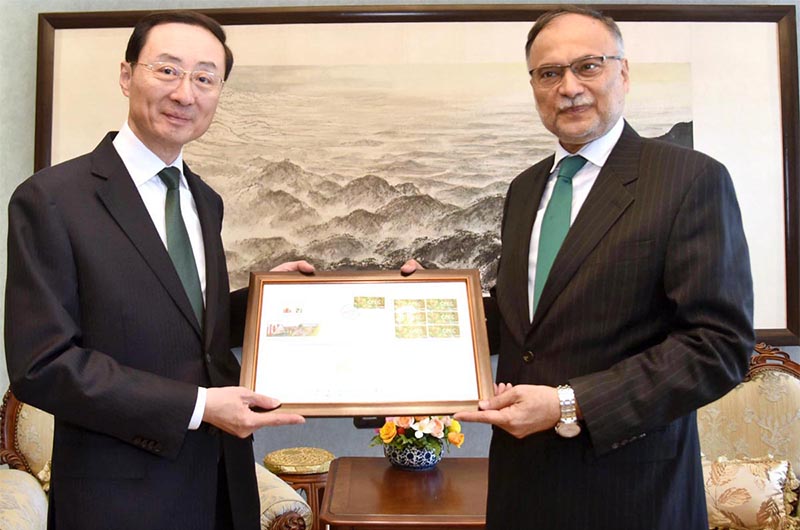 Federal Minister for Planning, Development and Special Initiative Prof. Ahsan Iqbal presenting commemorative coin and postage stamp which launched to celebrate the