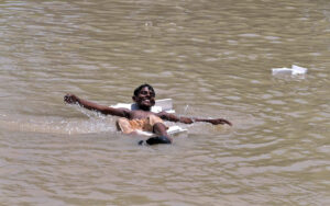 Youngster jumping and bathing in the canal to get relief from hot weather in the city.