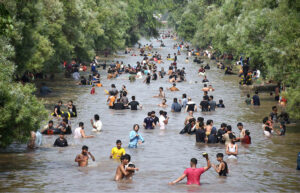 A large number of youngsters bathing in a canal to get relief from scorching hot weather due to increasing temperature in Provincial Capital