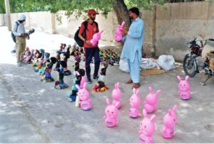 A vendor is selling inflatable toys at roadside.